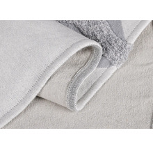 Detailní záběr světlé textilní koupelnové předložky