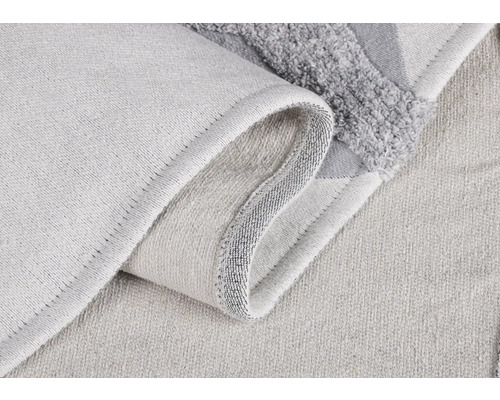 Detailní záběr světlé textilní koupelnové předložky