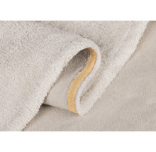 Detailní pohled na světlý koupelnový kobereček s měkkým povrchem