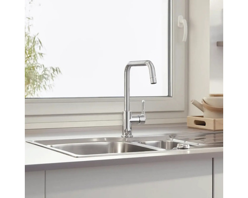 Kuchyňský dřez s baterií před oknem