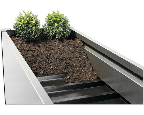 Detailní pohled na osázený truhlík se zeminou a rostlinami