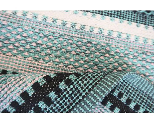 Detail tkaného koberce s geometrickým vzorem