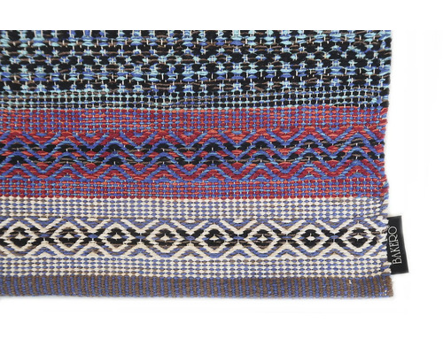 Detailní pohled na koberec s geometrickými vzory a logem Bakerø.