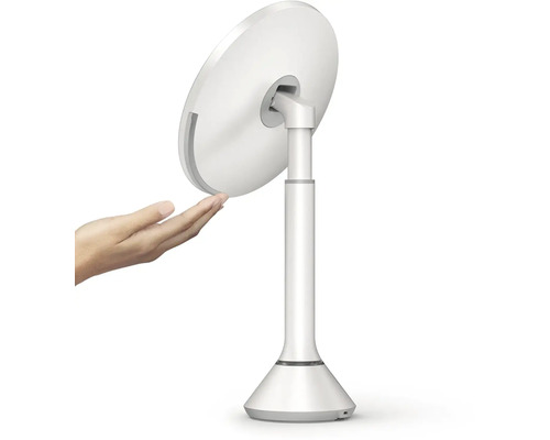 Bílé kosmetické zrcadlo se stojanem a rukou na obrázku.