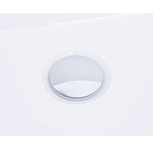 Detailní pohled na kulatý chromovaný výpustný ventil v umyvadle.