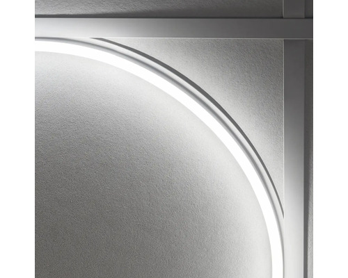 Detail nástěnné lampy s rámem a kruhovým světelným prvkem.