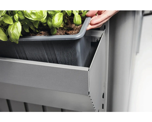 Osoba umisťuje truhlík do šedého kovového regálu