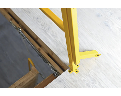 Detailní pohled na půdní schody se žlutým zábradlím