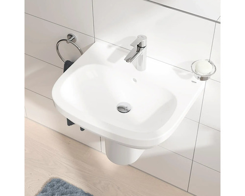 Snímek koupelny s umyvadlem, kruhem na ručníky, vodovodní baterií a miskou na mýdlo.