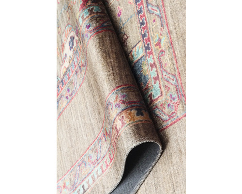 Detailní pohled na vzorovaný koberec, který je částečně srolovaný