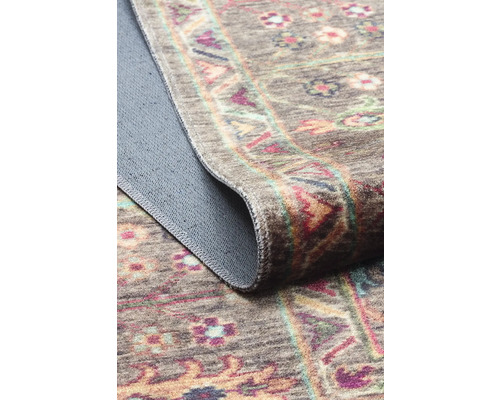 Koberec s květinovým vzorem a ohrnutým okrajem.