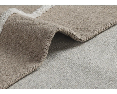 Detailní pohled na béžový koberec s okrajem s vysokým vlasem