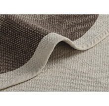 Detailní pohled na béžový a hnědý koupelnový koberec