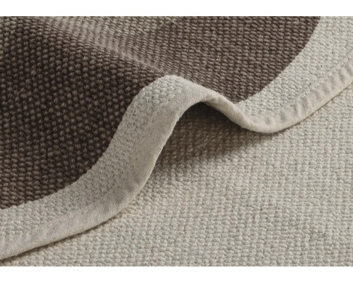 Detailní pohled na béžový a hnědý koupelnový koberec