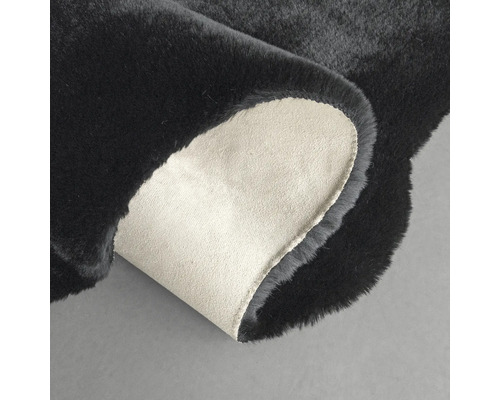 Černý koberec s ohnutým rohem pro zobrazení zadní strany