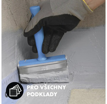 Osoba nanáší štětcem nátěr na povrch.