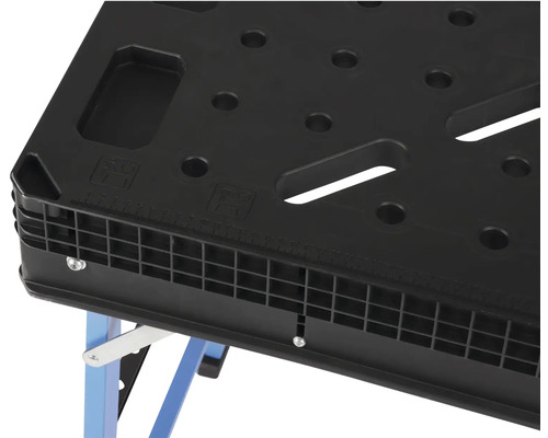 Detailní pohled na pracovní stůl s děrovanou deskou a modrýma nohama.