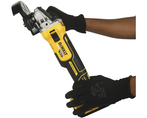 Akumulátorová úhlová bruska Dewalt držená v rukou v rukavicích