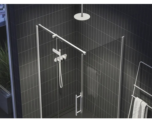 Sprchový kout se skleněnými dveřmi, sprchovou hlavicí a ohřívačem ručníků v koupelně s tmavými dlaždicemi