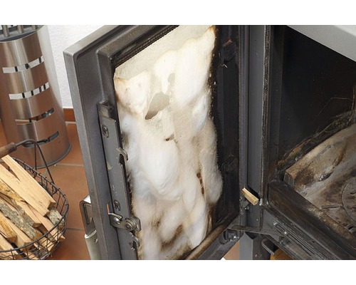 Otevřená dvířka kamen s izolací a košem na dřevo