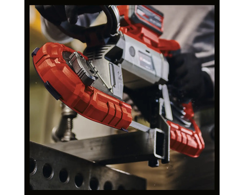 Akumulátorová pásová pila při řezání kovu.