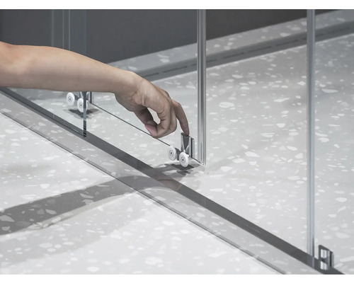 Detail sprchového koutu s posuvnými dveřmi a válečkovým mechanismem.