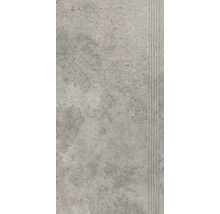 Šedá podlahová dlaždice s rýhovaným okrajem.