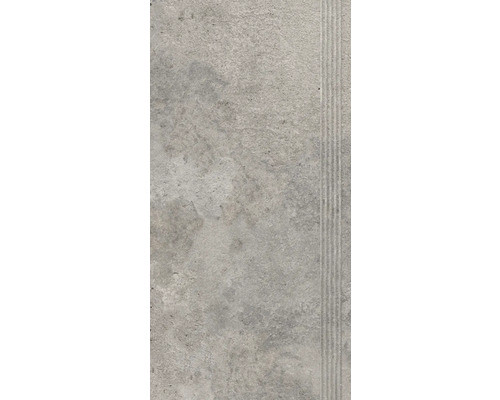 Šedá podlahová dlaždice s rýhovaným okrajem.