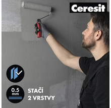 Muž maluje šedou stěnu válečkem na barvu. Logo Ceresit.