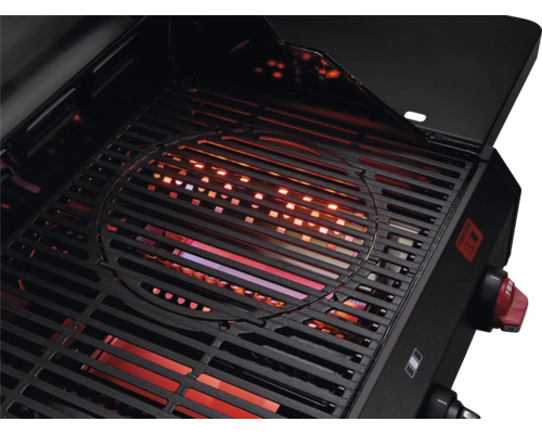 Pohled do otevřeného grilu s grilovacím roštem a zapnutým topením