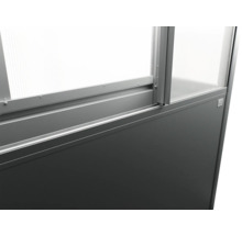 Detailní pohled na rám skleníku se skleněnými panely a šedou základnou