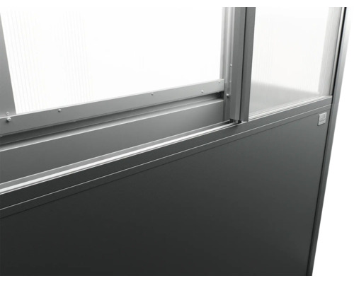 Detailní pohled na rám skleníku se skleněnými panely a šedou základnou