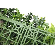 Umělá rostlinná stěna se zelenými listy a plastovou mřížkou