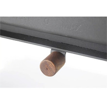 Detail černých kamen s dřevěnou rukojetí a značkami pro minimální a maximální úroveň.