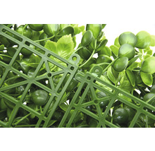 Detailní pohled na umělý rostlinný panel se zelenými listy a plastovou mřížkou