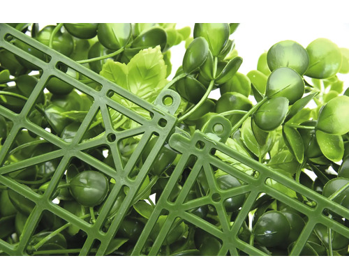 Detailní pohled na umělý rostlinný panel se zelenými listy a plastovou mřížkou