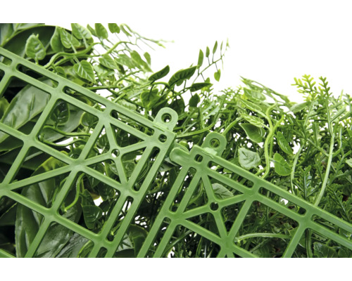 Detailní pohled na umělý živý plot se zelenými listy a plastovou mřížkou