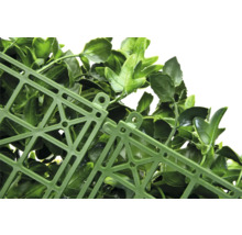 Detail umělého živého plotu s listy a mřížkovou strukturou