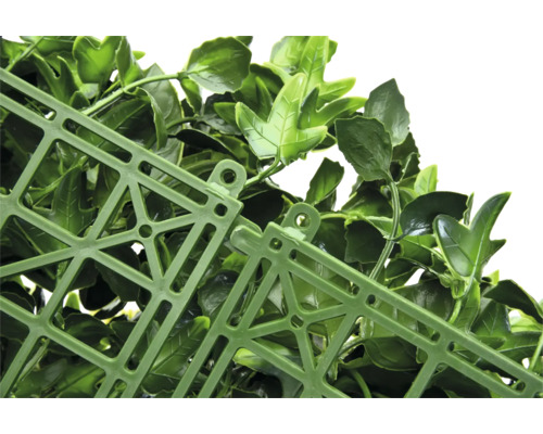 Detail umělého živého plotu s listy a mřížkovou strukturou