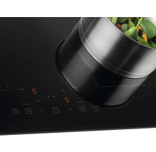 Indukční varná deska s hrncem a zeleninou.