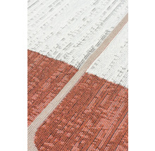 Detail tkaného koberce s geometrickým vzorem a různými texturami.