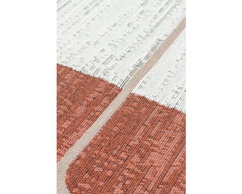 Detail tkaného koberce s geometrickým vzorem a různými texturami.