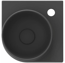 Pohled shora na černé umyvadlo na desku s otvorem pro vodovodní baterii