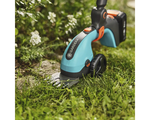 Akumulátorové nůžky na trávu Gardena používané v zahradě.