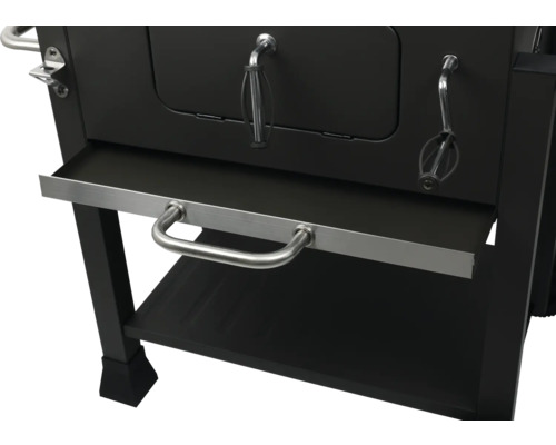 Detailní pohled na černý gril na dřevěné uhlí s úložným prostorem