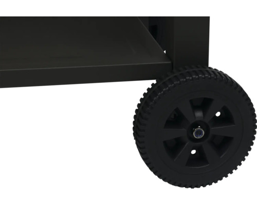 Detailní pohled na grilovací vozík s černým kolečkem.