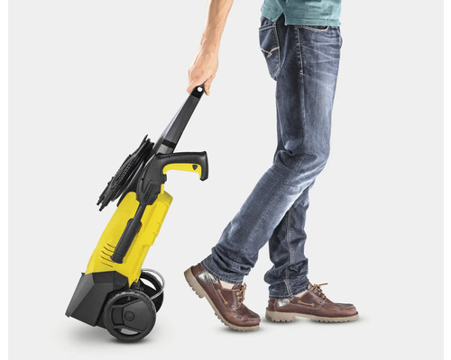 Osoba táhne žlutý vysokotlaký čistič.