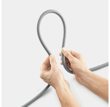 Šedou hadici drží dvě ruce.