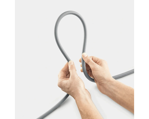 Šedá zavlažovací hadice držená dvěma rukama