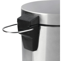 Detailní pohled na víko nášlapného koše s kovovým pedálovým mechanismem.